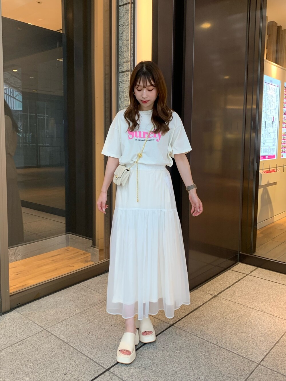 ホワイト系のTシャツ/カットソー、ホワイト系のスカート、ホワイト系のショルダーバッグを着用したレディースの夏コーディネートの2枚目の写真