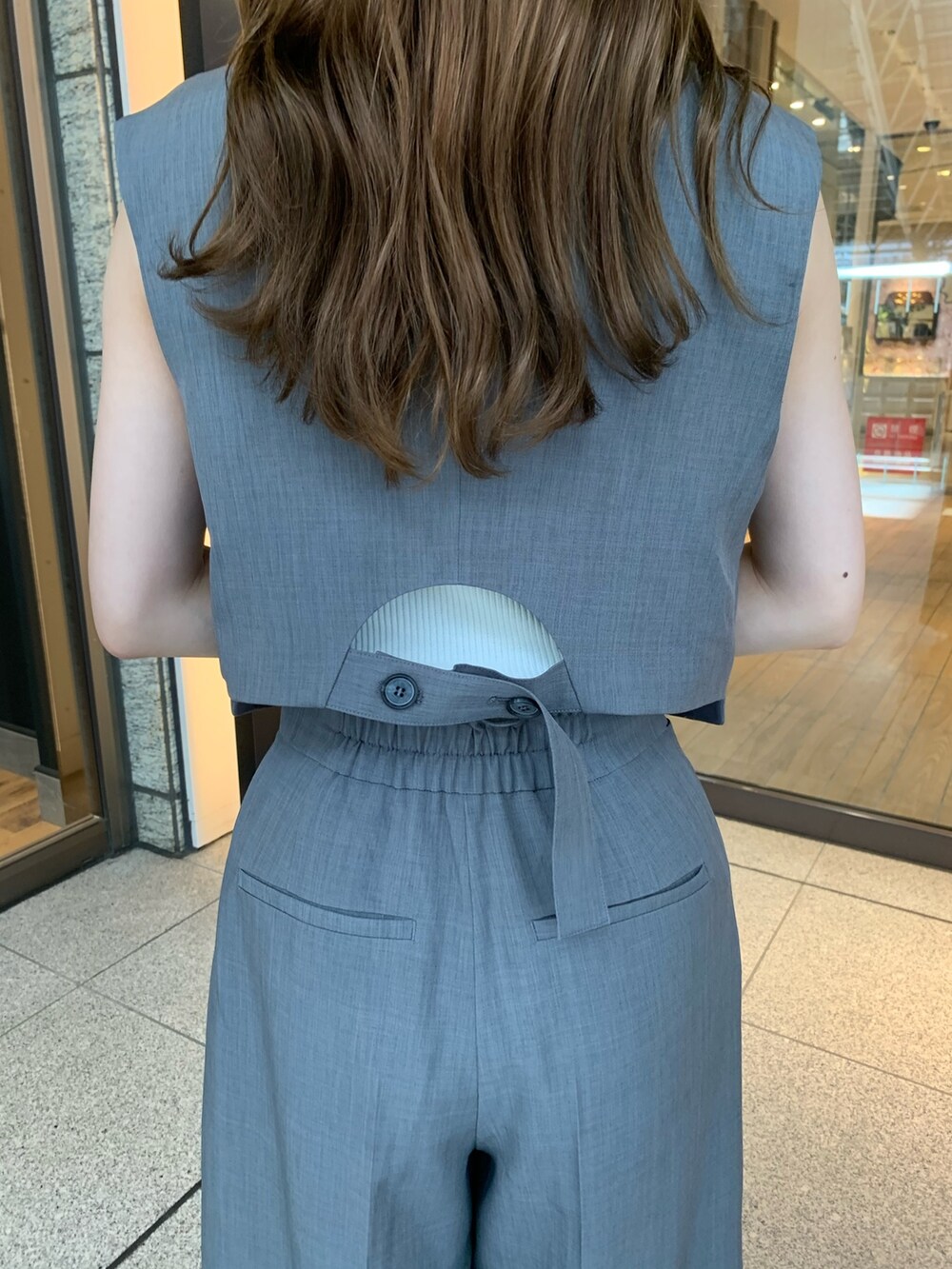 グレー系のスラックス、ブラック系のパンプス、グレー系のテーラードジャケットを着用したレディースの夏コーディネートの5枚目の写真