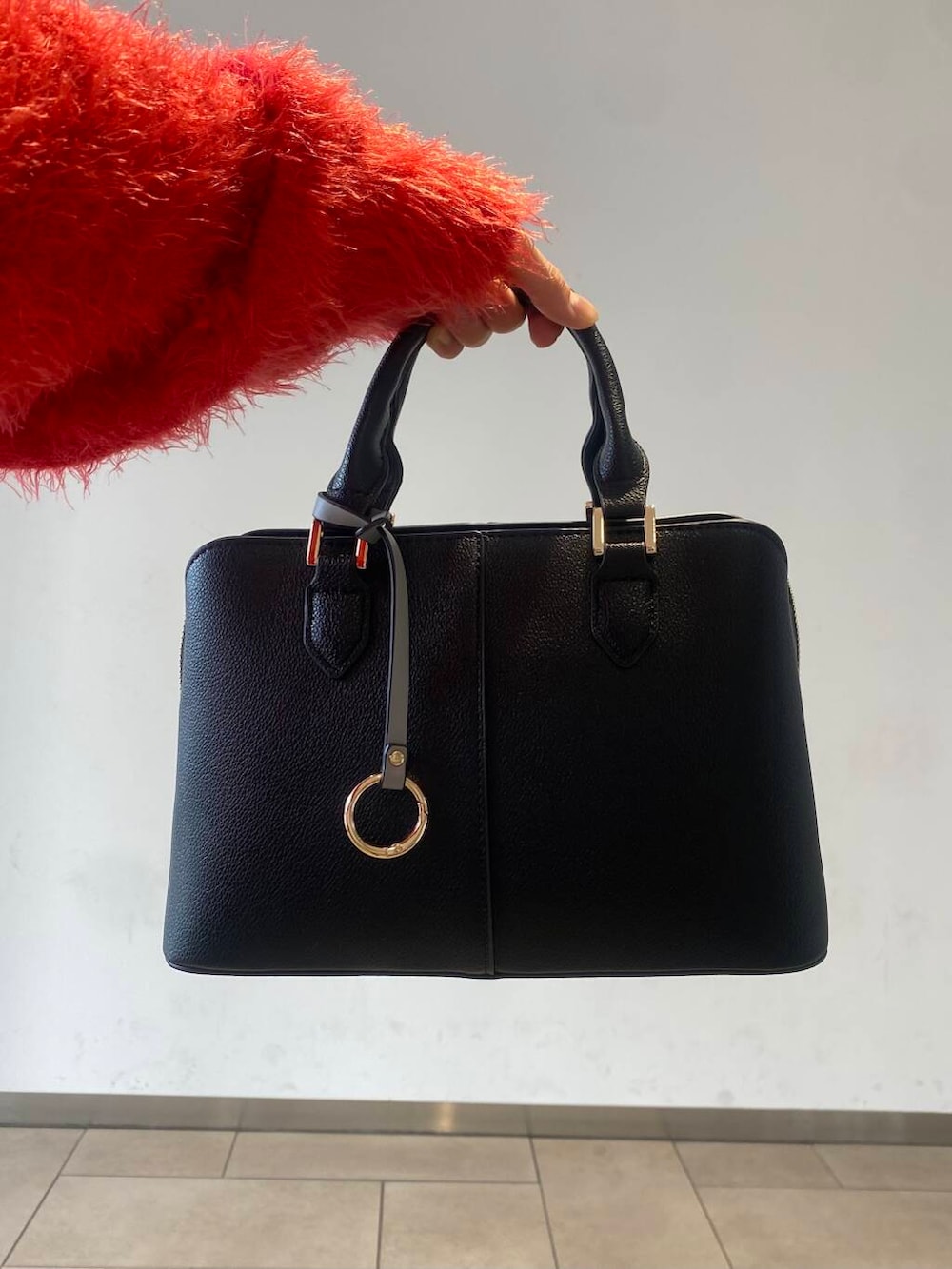 ブラック系のブーツ、ブラック系のハンドバッグ、レッド系のニット/セーターを着用したレディースの冬コーディネートの5枚目の写真