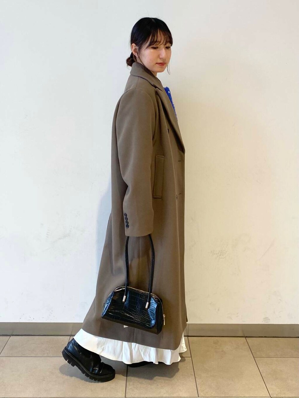 ブルー系のカーディガン/ボレロ、ブラック系のブーツ、ホワイト系のスカートを着用したレディースの冬コーディネートの4枚目の写真