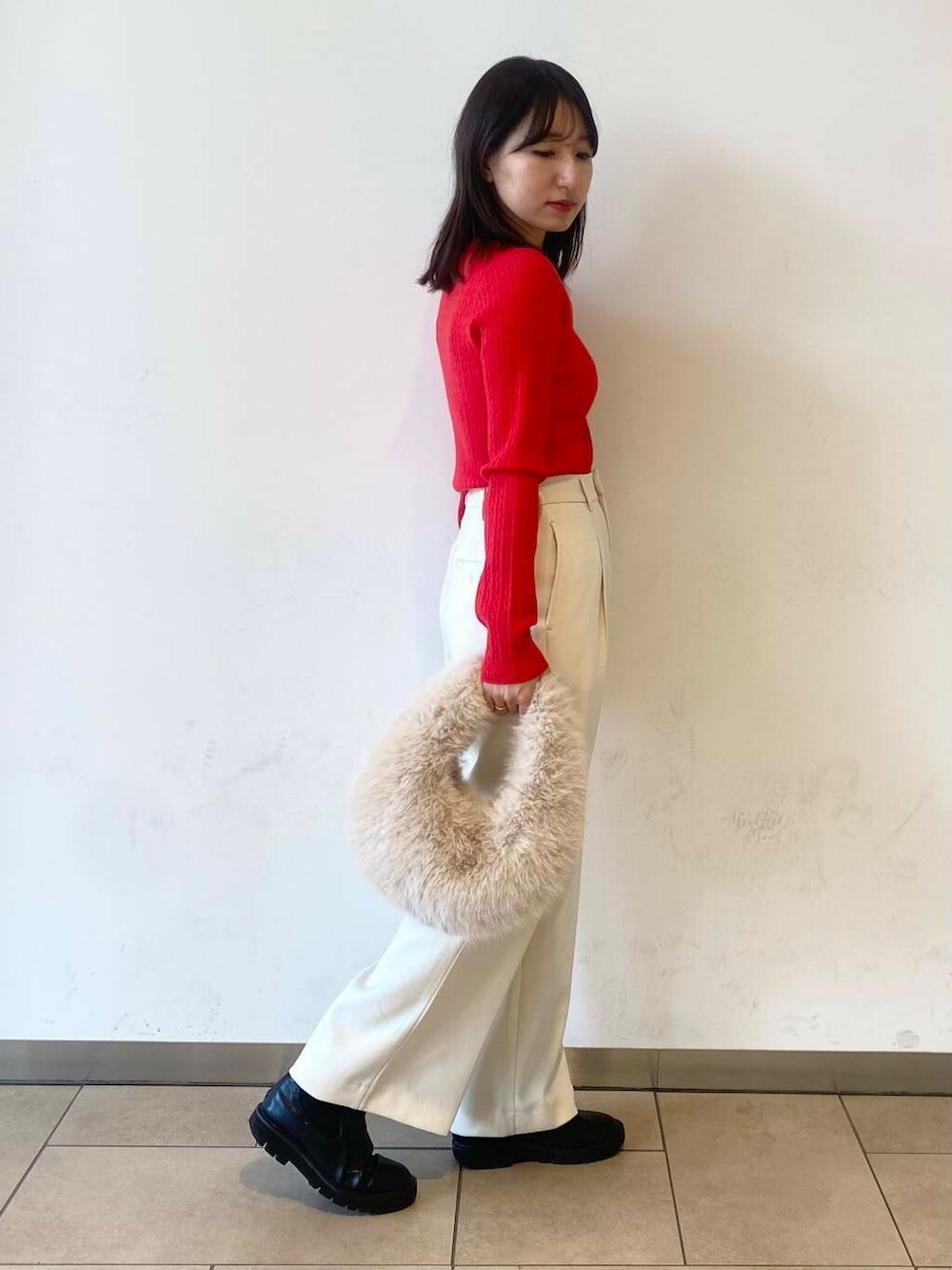 ベージュ系のハンドバッグ、ブラック系のブーツ、グレー系のその他アウターを着用したレディースの冬コーディネートの3枚目の写真