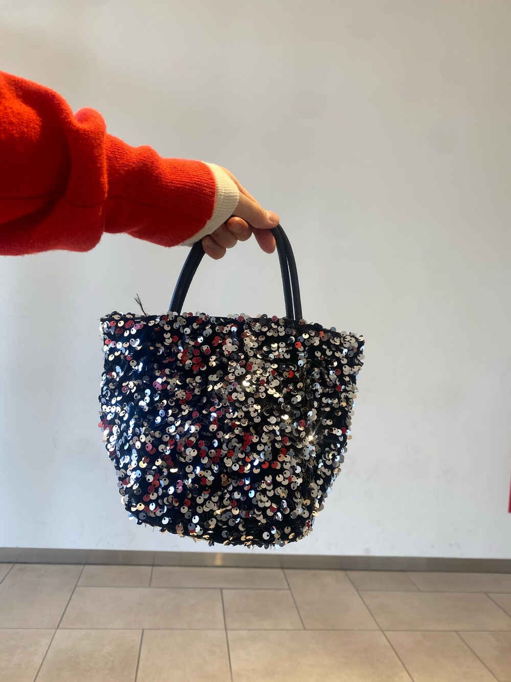 レッド系のカーディガン/ボレロ、ホワイト系のTシャツ/カットソー、ブルー系のデニムパンツを着用したレディースの冬コーディネートの3枚目の写真