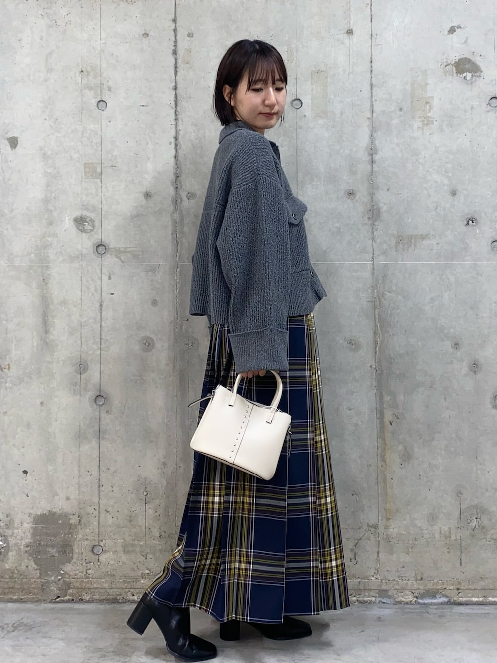 その他のスカート、グレー系のその他アウター、ブラック系のブーツを着用したレディースの秋コーディネートの2枚目の写真