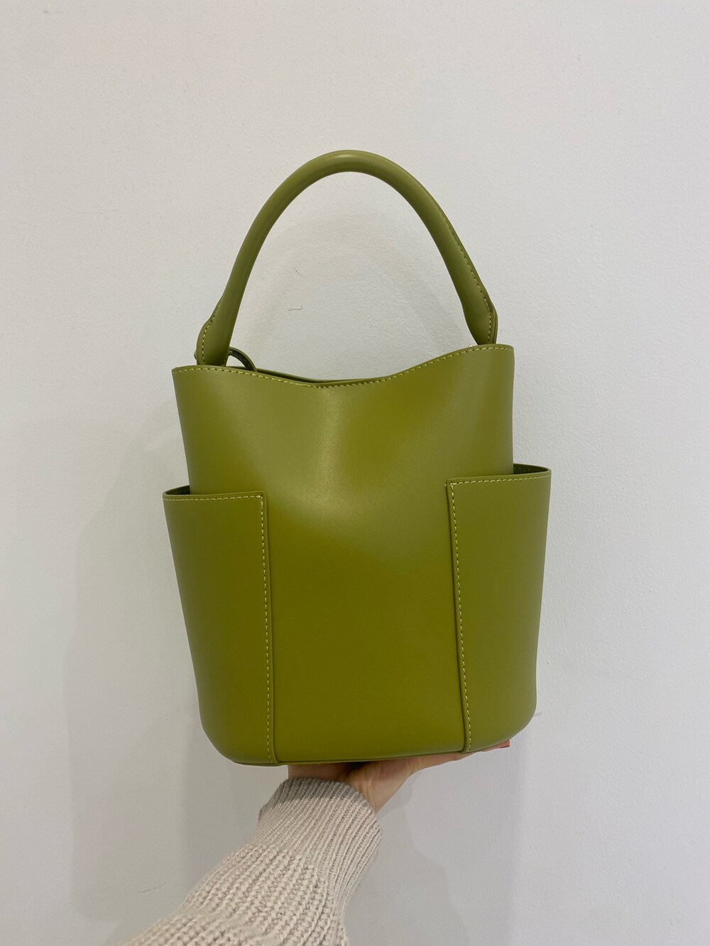 ベージュ系のワンピース、グリーン系のトートバッグ、ブラック系のブーツを着用したレディースの冬コーディネートの3枚目の写真