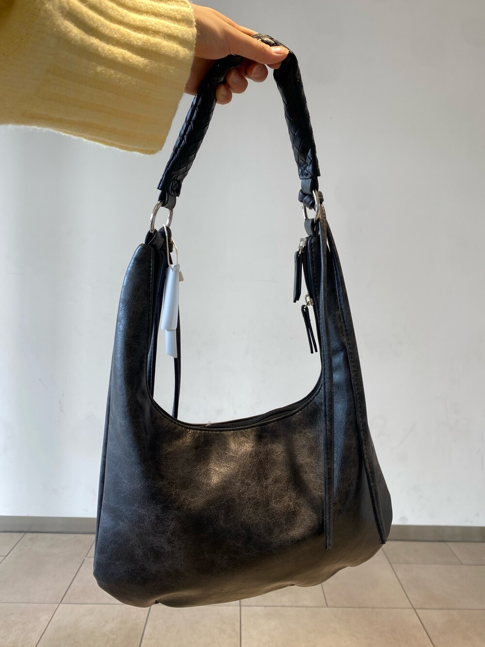 イエロー系のニット/セーター、グレー系のその他パンツ、ブラック系のブーツを着用したレディースの冬コーディネートの3枚目の写真