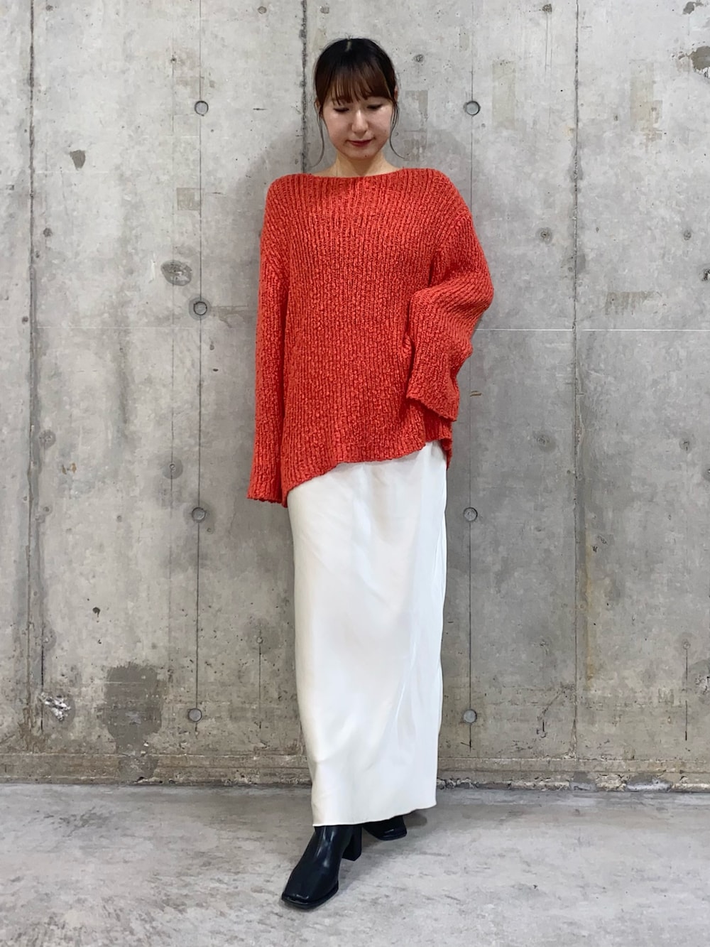 ブラウン系のその他アウター、レッド系のニット/セーター、ホワイト系のスカートを着用したレディースの秋コーディネートの2枚目の写真