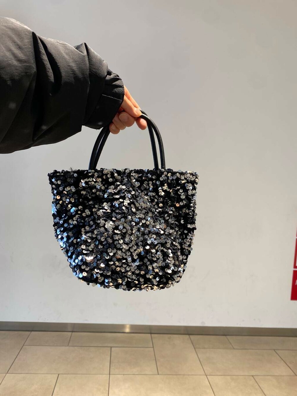 ブラック系のブーツ、グレー系のニット/セーター、ホワイト系のスカートを着用したレディースの冬コーディネートの5枚目の写真