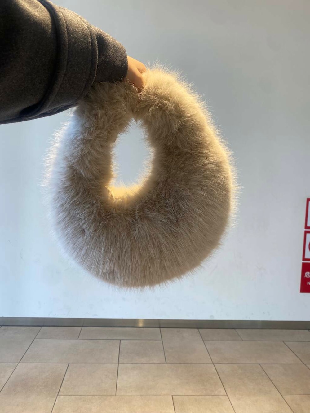 ベージュ系のハンドバッグ、ブラック系のブーツ、グレー系のその他アウターを着用したレディースの冬コーディネートの5枚目の写真