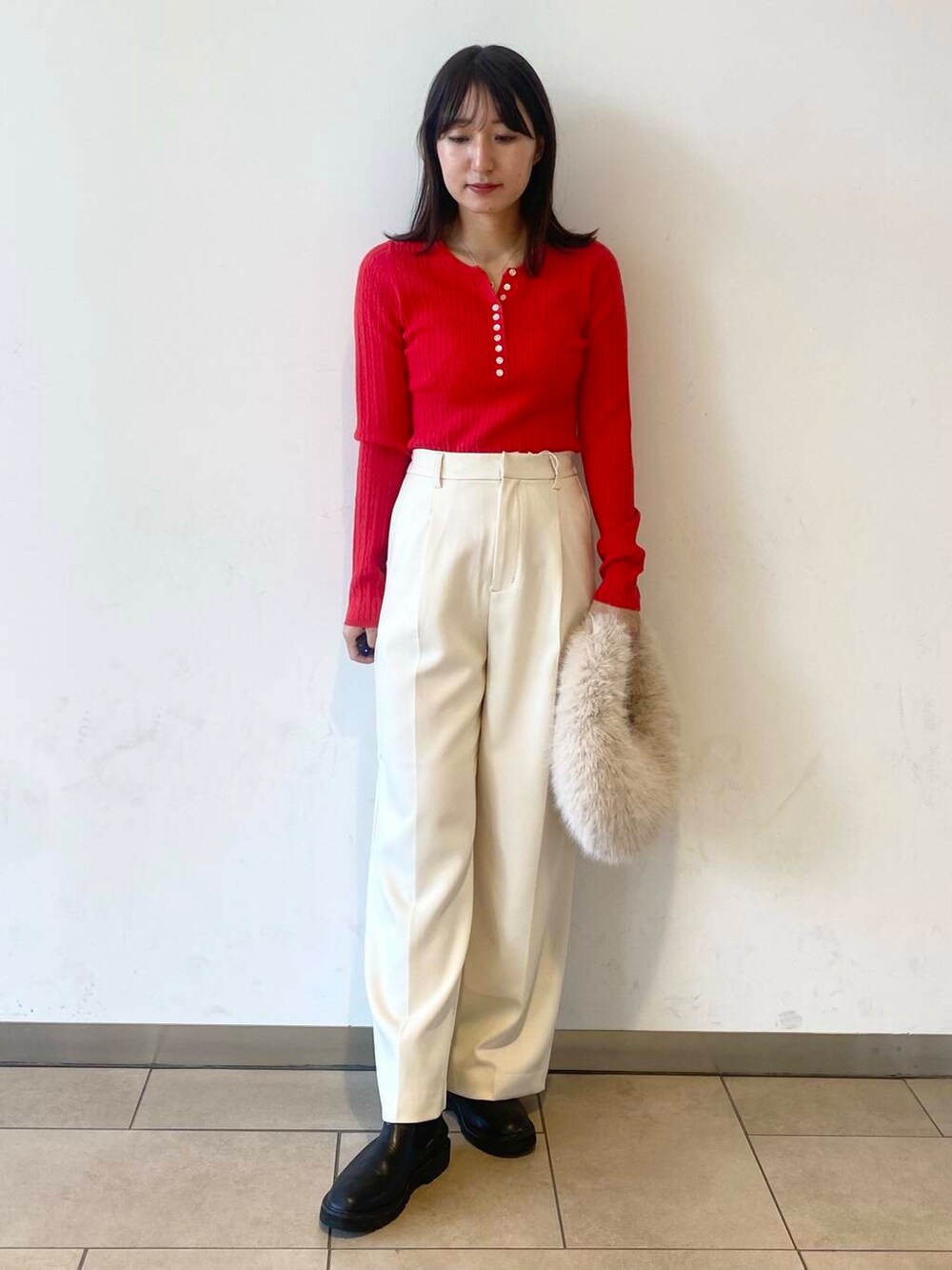 ベージュ系のハンドバッグ、ブラック系のブーツ、グレー系のその他アウターを着用したレディースの冬コーディネートの2枚目の写真