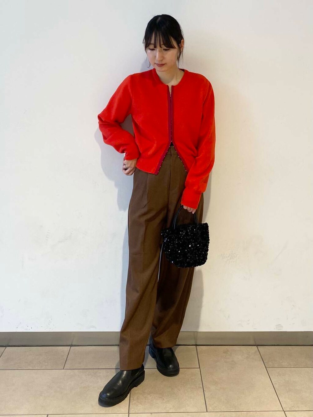 ブラック系のショルダーバッグ、ブラック系のブーツ、ベージュ系のその他アウターを着用したレディースの冬コーディネートの2枚目の写真