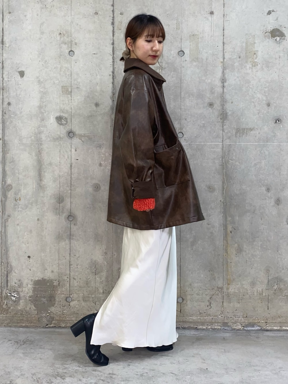 ブラウン系のその他アウター、レッド系のニット/セーター、ホワイト系のスカートを着用したレディースの秋コーディネートの3枚目の写真