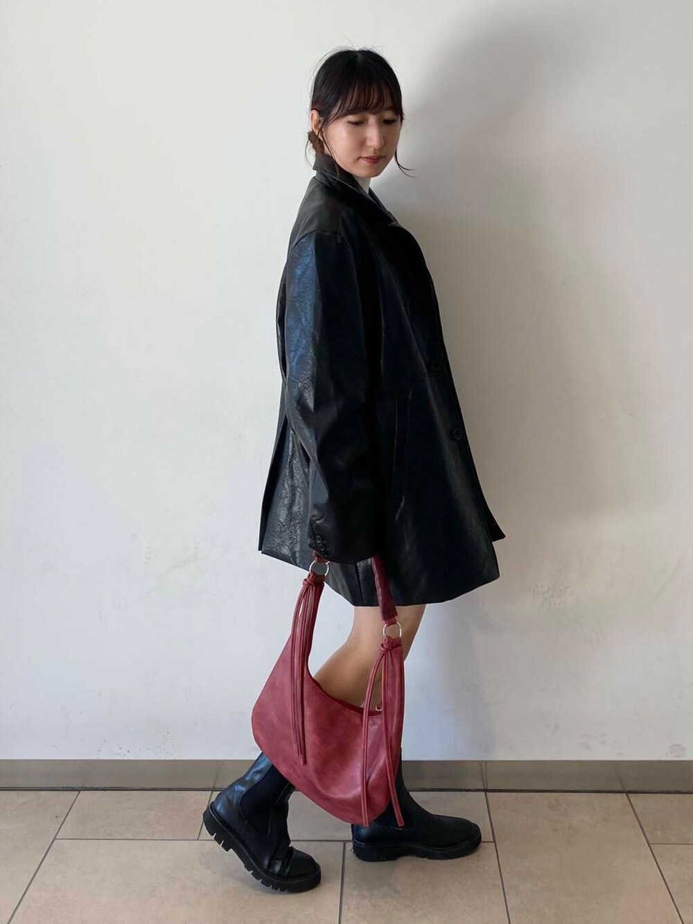 ホワイト系のニット/セーター、ブラック系のブーツ、グレー系のその他パンツを着用したレディースの秋コーディネートの2枚目の写真