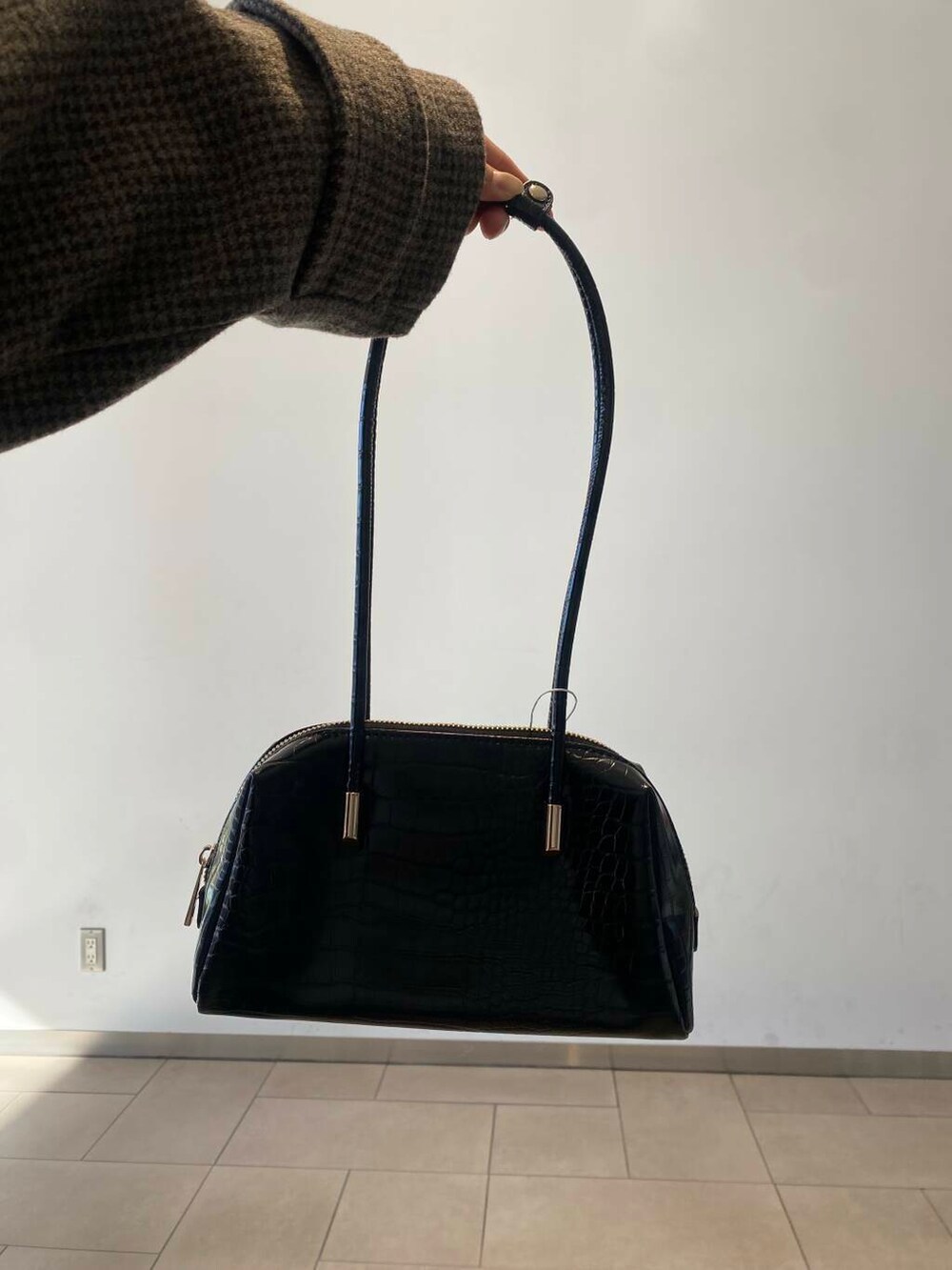 ホワイト系のスカート、ブラック系のブーツ、ブラック系のハンドバッグを着用したレディースの冬コーディネートの5枚目の写真