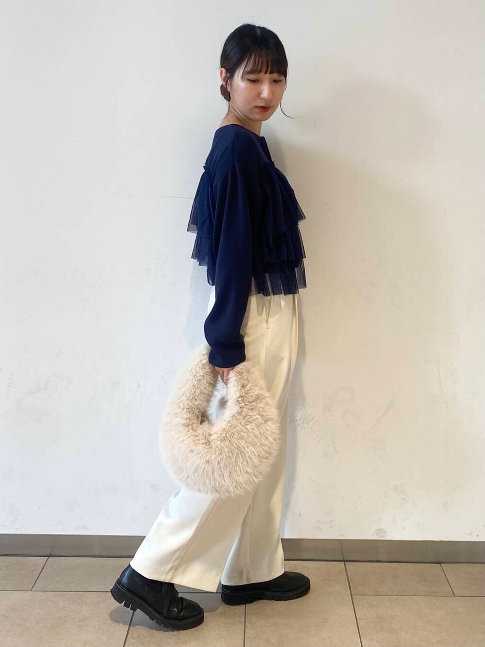 ベージュ系のハンドバッグ、ブラック系のブーツ、ホワイト系のその他パンツを着用したレディースの秋コーディネートの2枚目の写真