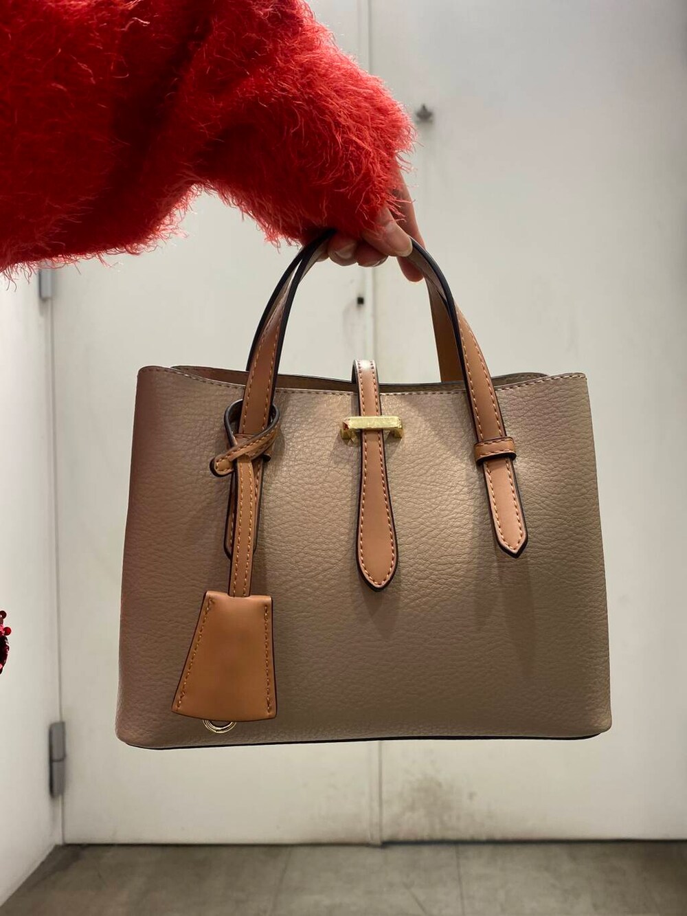 ベージュ系のハンドバッグ、ブラック系のブーツ、レッド系のニット/セーターを着用したレディースの冬コーディネートの5枚目の写真