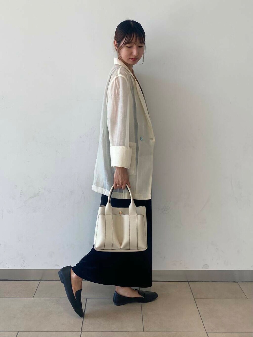 ブラック系のローファー、ホワイト系のトートバッグ、ブラウン系のキャミソールを着用したレディースの秋コーディネートの2枚目の写真