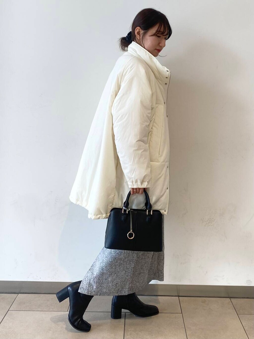 ブラック系のブーツ、ブラック系のハンドバッグ、レッド系のニット/セーターを着用したレディースの冬コーディネートの4枚目の写真