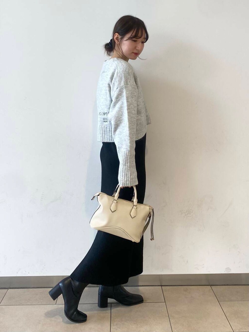 ブラック系のブーツ、グレー系のワンピースを着用したレディースの冬コーディネートの2枚目の写真