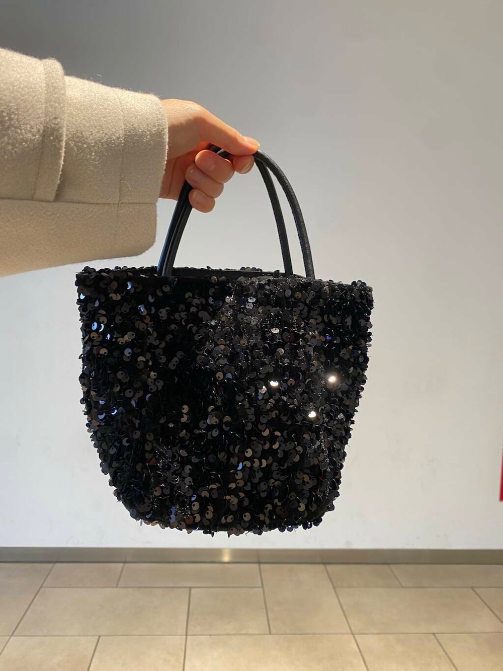 ブラック系のショルダーバッグ、ブラック系のブーツ、ベージュ系のその他アウターを着用したレディースの冬コーディネートの3枚目の写真