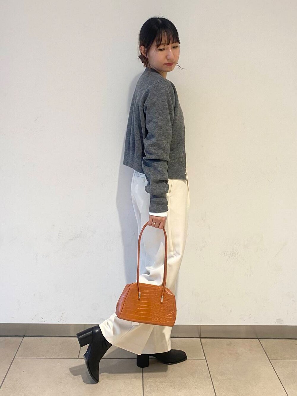 ブラック系のブーツ、その他のTシャツ/カットソー、オレンジ系のハンドバッグを着用したレディースの秋コーディネートの2枚目の写真