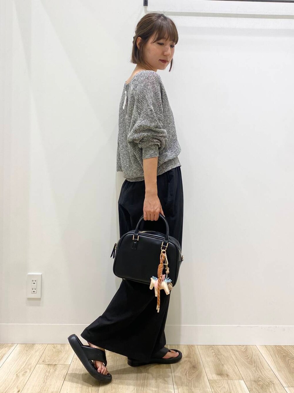 ブラック系のその他パンツ、ブラック系のボストンバッグ、ブラック系のカーディガン/ボレロを着用したレディースの夏コーディネートの2枚目の写真