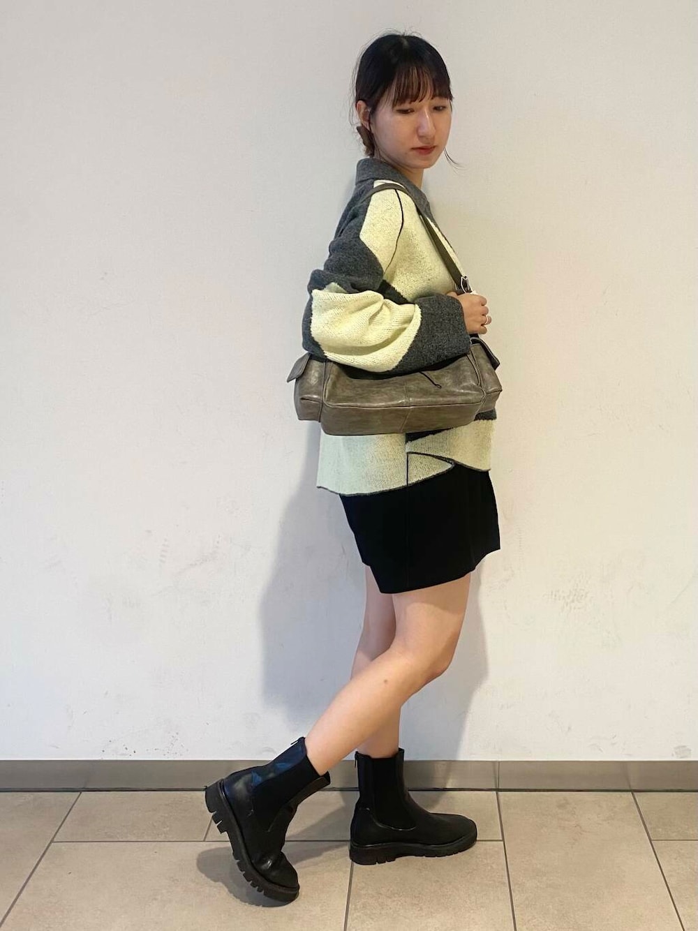 ブラック系のブーツ、グレー系のハンドバッグ、ブラック系のその他パンツを着用したレディースの秋コーディネートの2枚目の写真