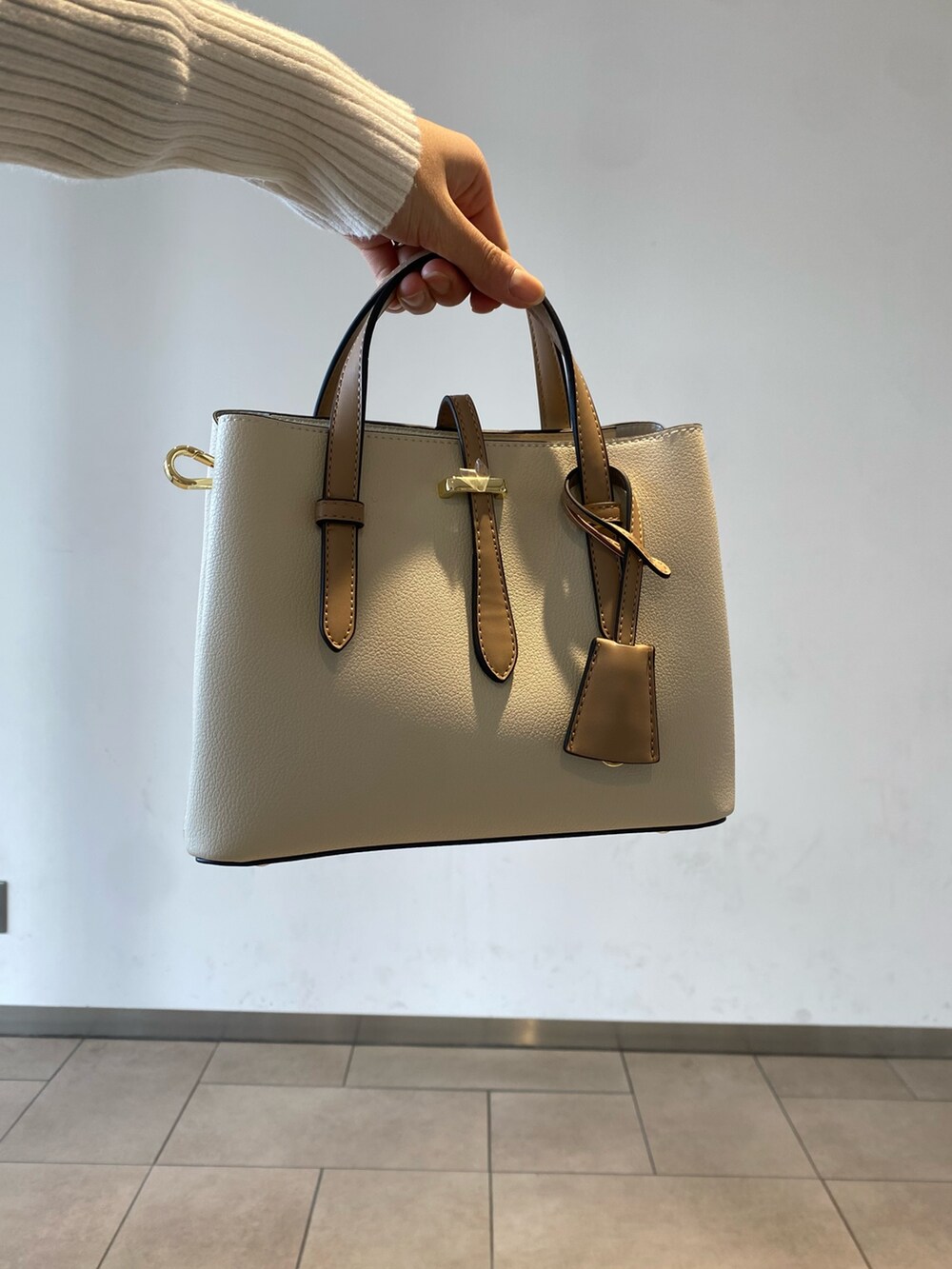 ホワイト系のニット/セーター、ブラック系のブーツ、ブラック系のベストを着用したレディースの冬コーディネートの3枚目の写真