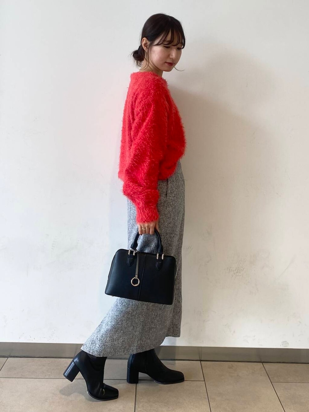 ブラック系のブーツ、ブラック系のハンドバッグ、レッド系のニット/セーターを着用したレディースの冬コーディネートの3枚目の写真