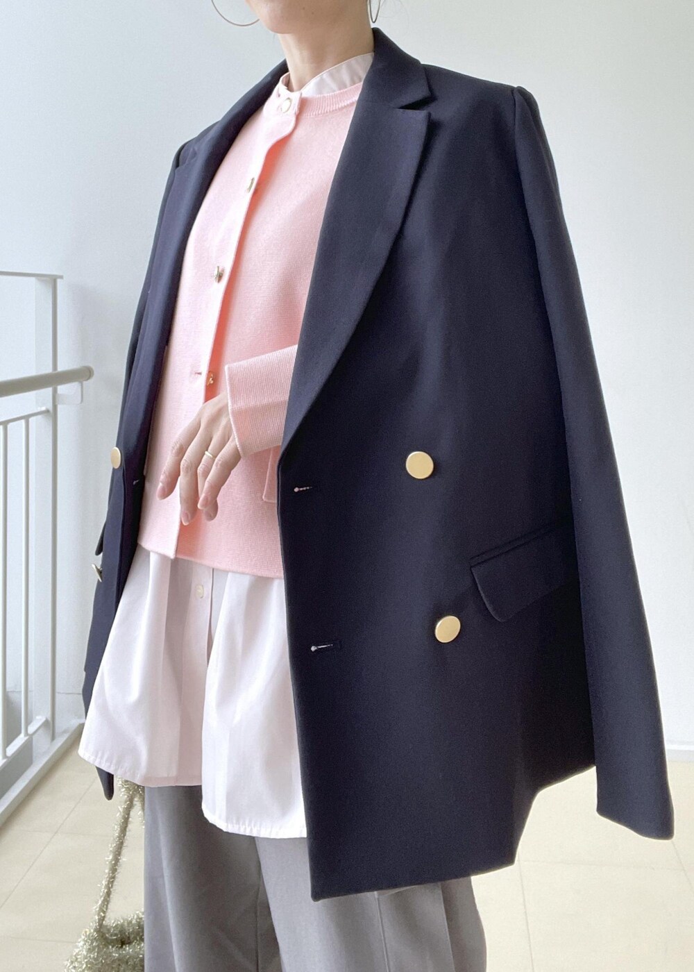 ゴールド系のショルダーバッグ、ブルー系のテーラードジャケット、ゴールド系のバレエシューズを着用したレディースの冬コーディネートの6枚目の写真