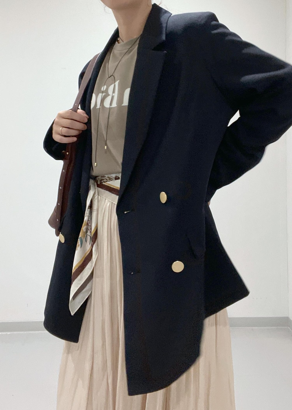 イエロー系のローファー、ベージュ系のスカート、レッド系のショルダーバッグを着用したレディースの夏コーディネートの5枚目の写真