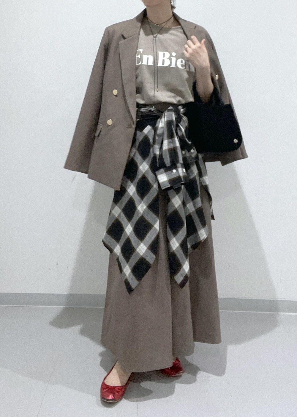 ベージュ系のスカート、ベージュ系のテーラードジャケット、ブラック系のシャツ/ブラウスを着用したレディースの夏コーディネートの4枚目の写真