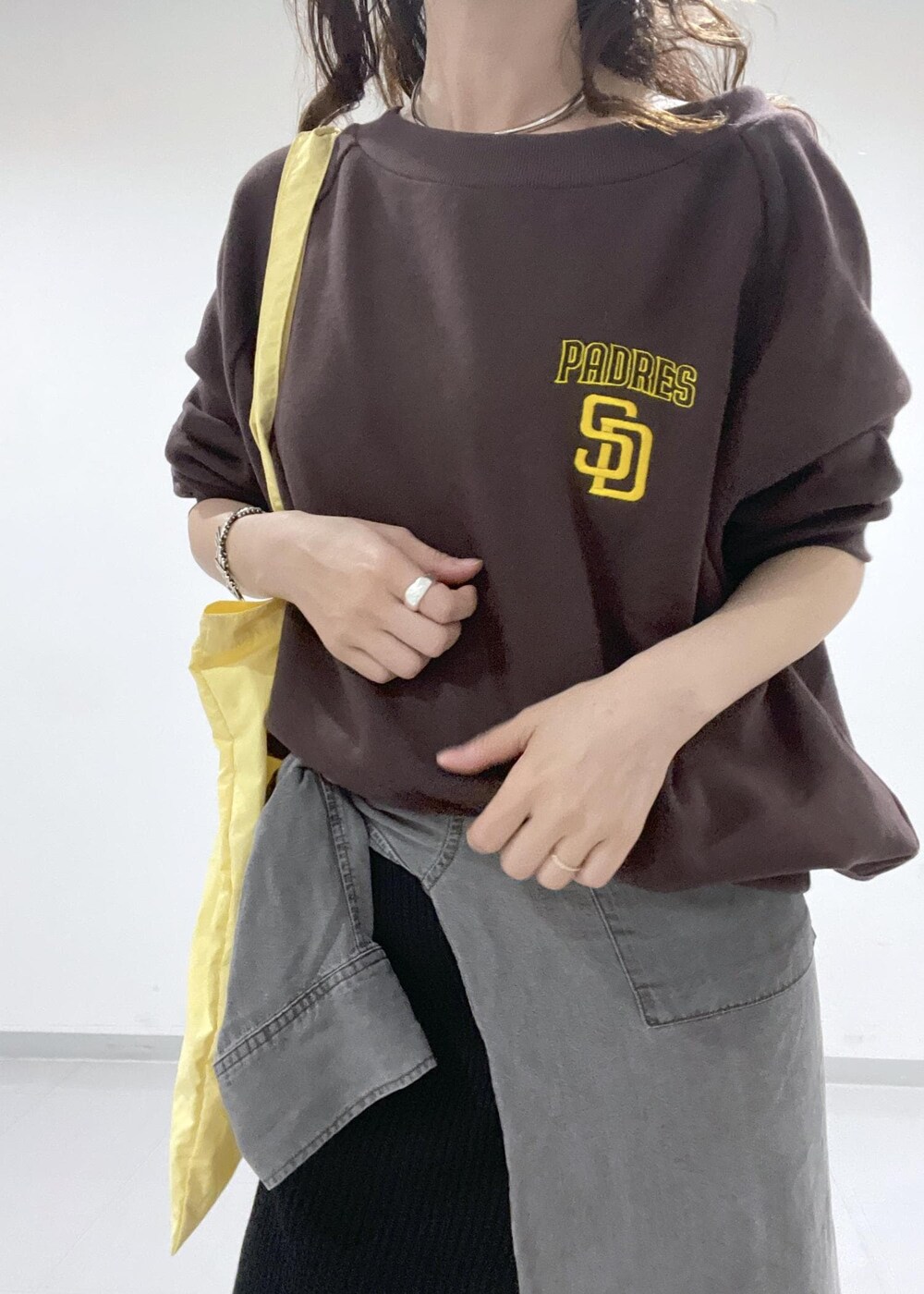 ブラック系のレインシューズ、グレー系のシャツ/ブラウス、ブラック系のスカートを着用したレディースの秋コーディネートの3枚目の写真