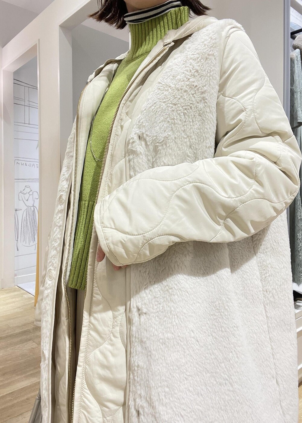 シルバー系のトートバッグ、グリーン系のニット/セーター、ホワイト系のブーツを着用したレディースの冬コーディネートの4枚目の写真