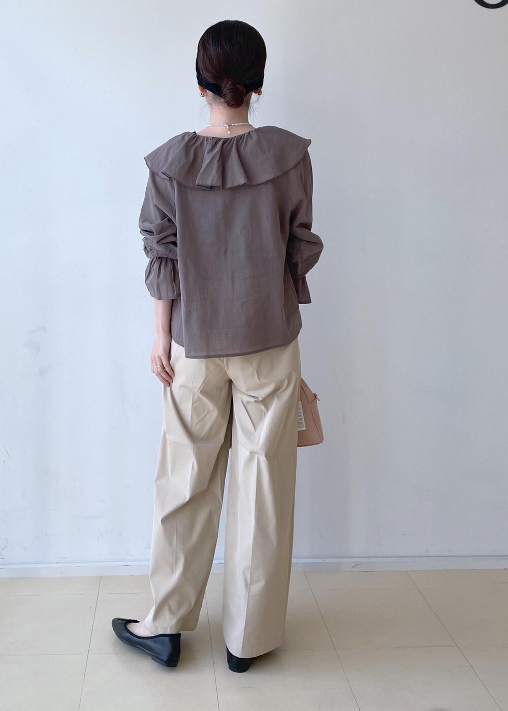 ベージュ系のチノパンツ、ピンク系のボストンバッグ、ブラック系のバレエシューズを着用したレディースの春コーディネートの5枚目の写真