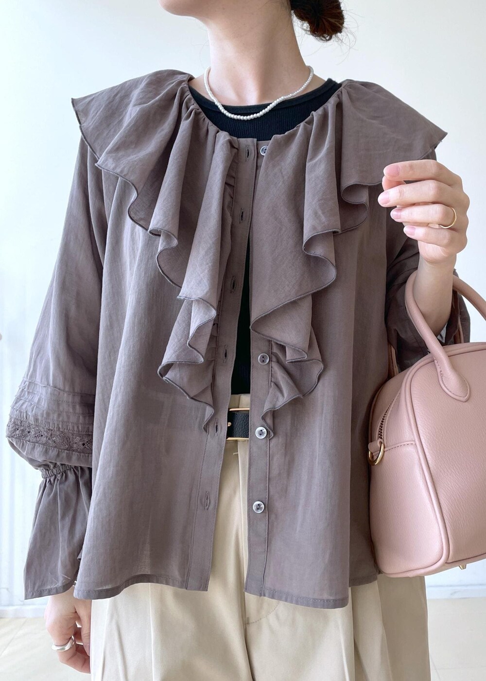 ベージュ系のチノパンツ、ピンク系のボストンバッグ、ブラック系のバレエシューズを着用したレディースの春コーディネートの6枚目の写真