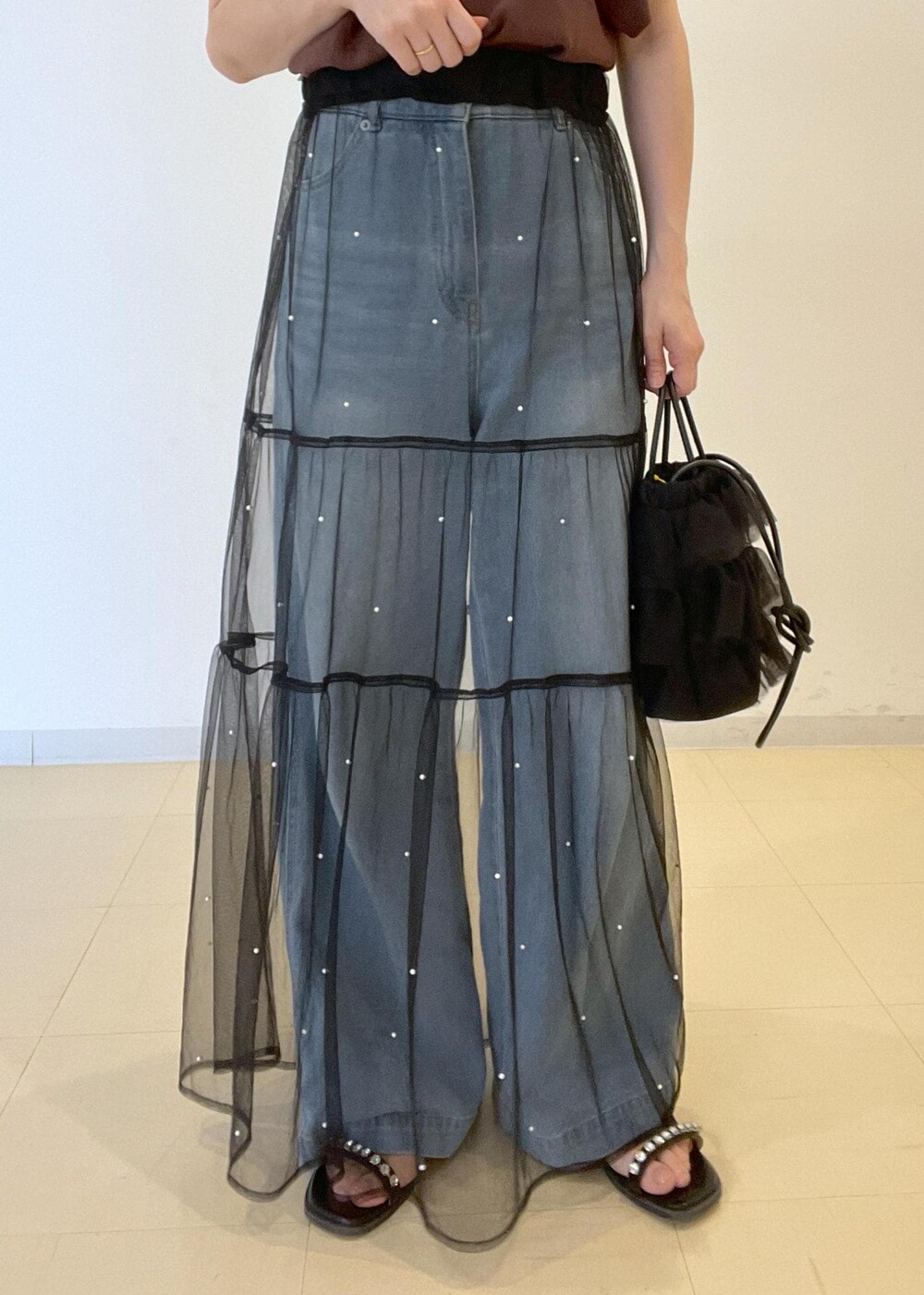 ブルー系のデニムパンツ、ブラック系のサンダル、ブラウン系のニット/セーターを着用したレディースの夏コーディネートの6枚目の写真