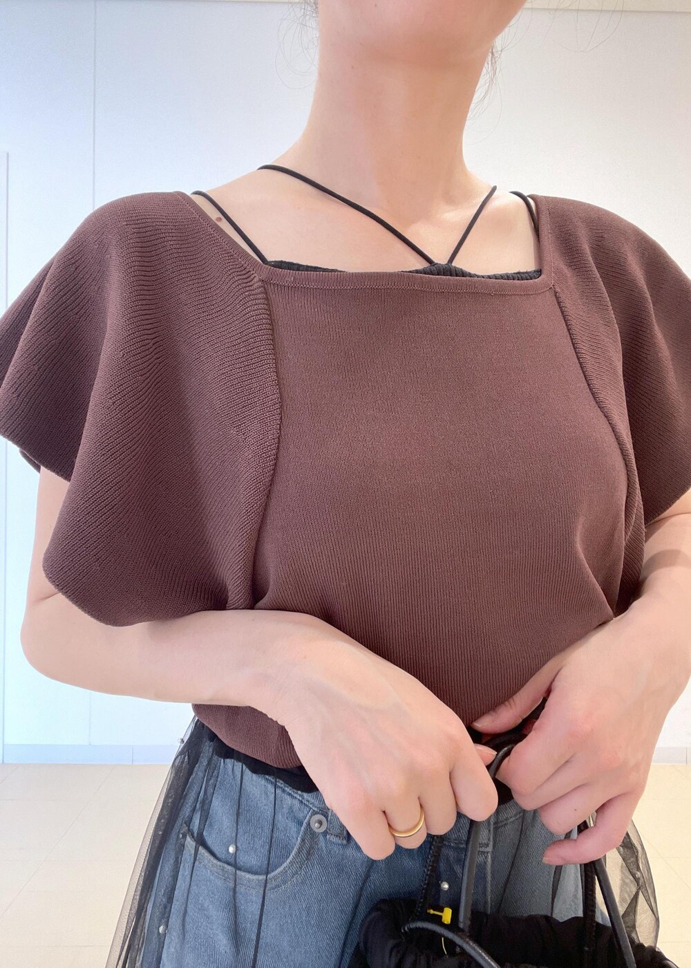 ブルー系のデニムパンツ、ブラック系のサンダル、ブラウン系のニット/セーターを着用したレディースの夏コーディネートの5枚目の写真