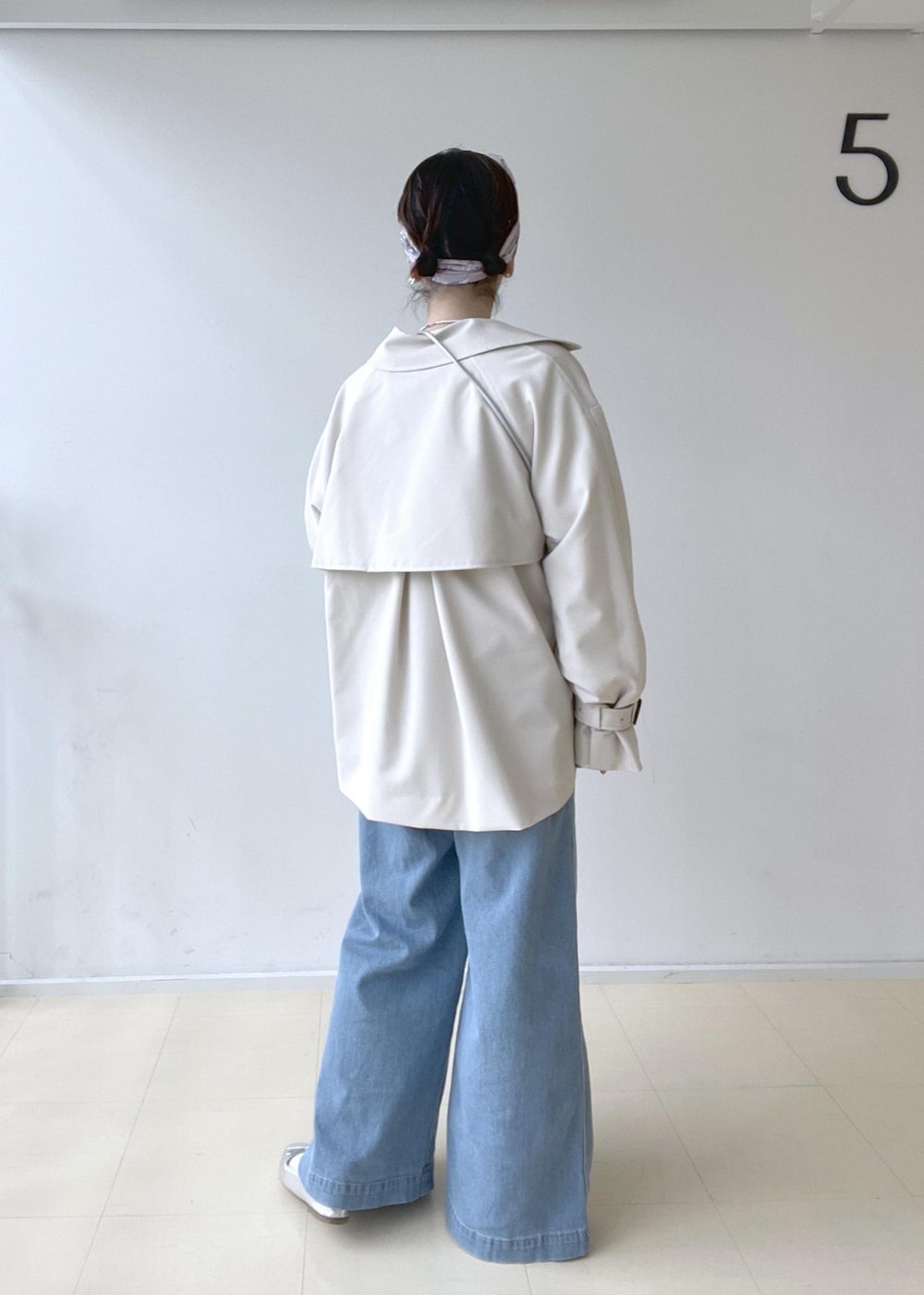 ベージュ系のトレンチコート、ホワイト系のニット/セーター、ホワイト系のTシャツ/カットソーを着用したレディースの冬コーディネートの3枚目の写真