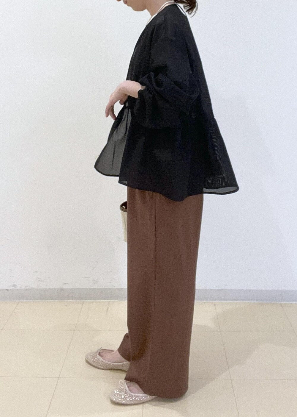 ブラック系のブルゾン、ホワイト系のバレエシューズ、ブラウン系のトートバッグを着用したレディースの春コーディネートの4枚目の写真