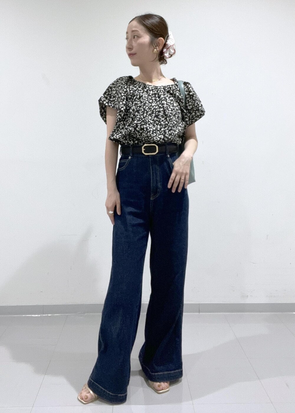 ブラック系のシャツ/ブラウス、ゴールド系のサンダル、ブルー系のショルダーバッグを着用したレディースの夏コーディネートの2枚目の写真