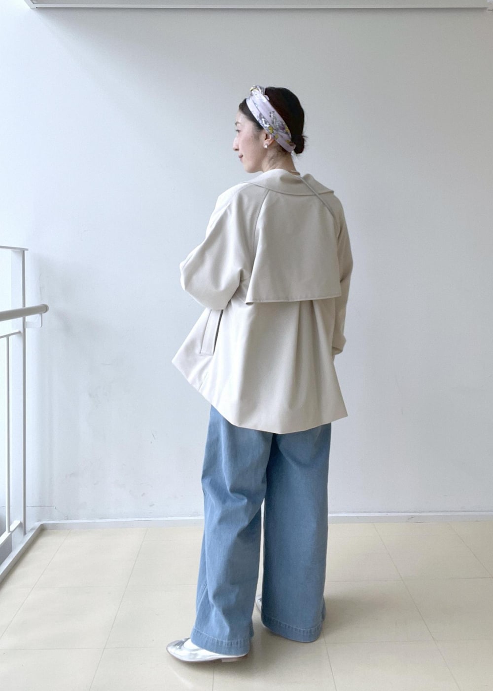 ベージュ系のトレンチコート、ホワイト系のニット/セーター、ホワイト系のTシャツ/カットソーを着用したレディースの冬コーディネートの2枚目の写真