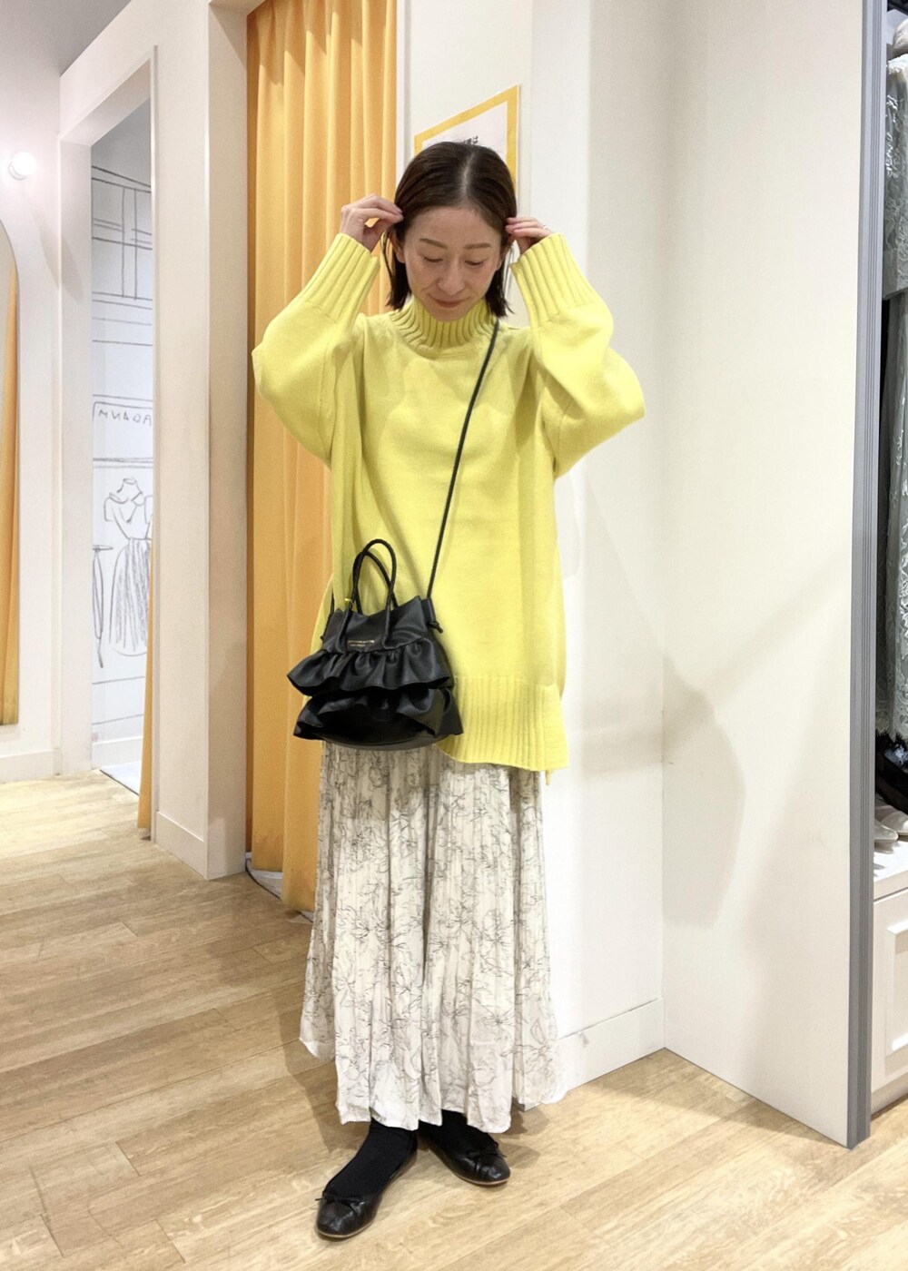ホワイト系のスカート、イエロー系のニット/セーター、ブラウン系のその他アウターを着用したレディースの冬コーディネートの3枚目の写真