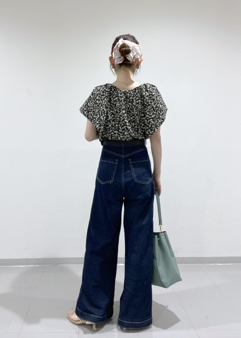 ブラック系のシャツ/ブラウス、ゴールド系のサンダル、ブルー系のショルダーバッグを着用したレディースの夏コーディネートの3枚目の写真