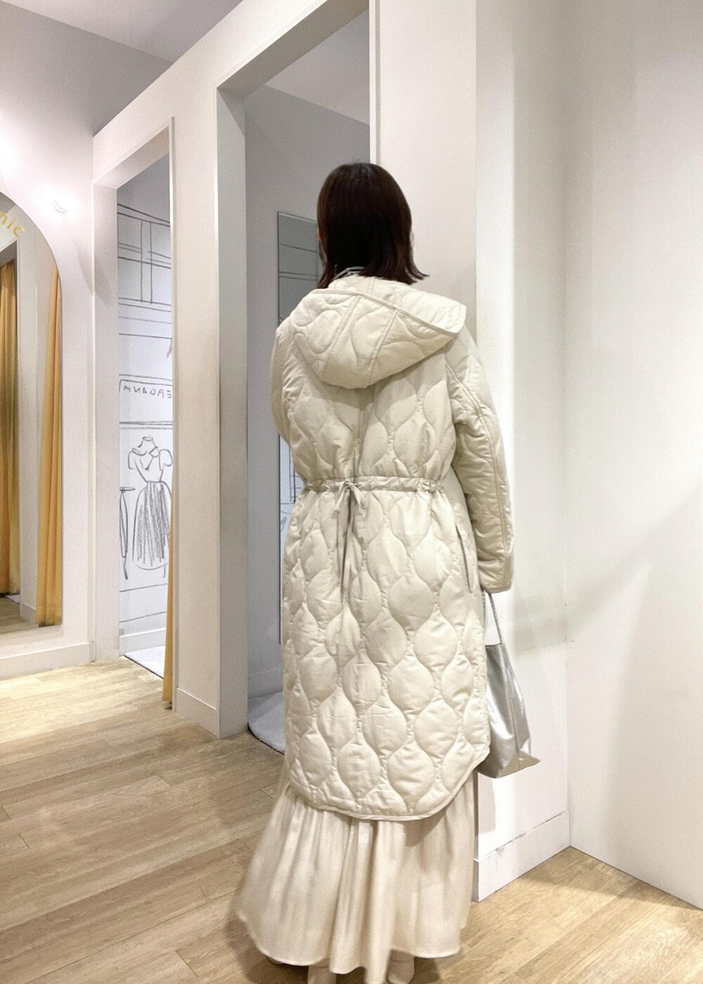 シルバー系のトートバッグ、グリーン系のニット/セーター、ホワイト系のブーツを着用したレディースの冬コーディネートの2枚目の写真