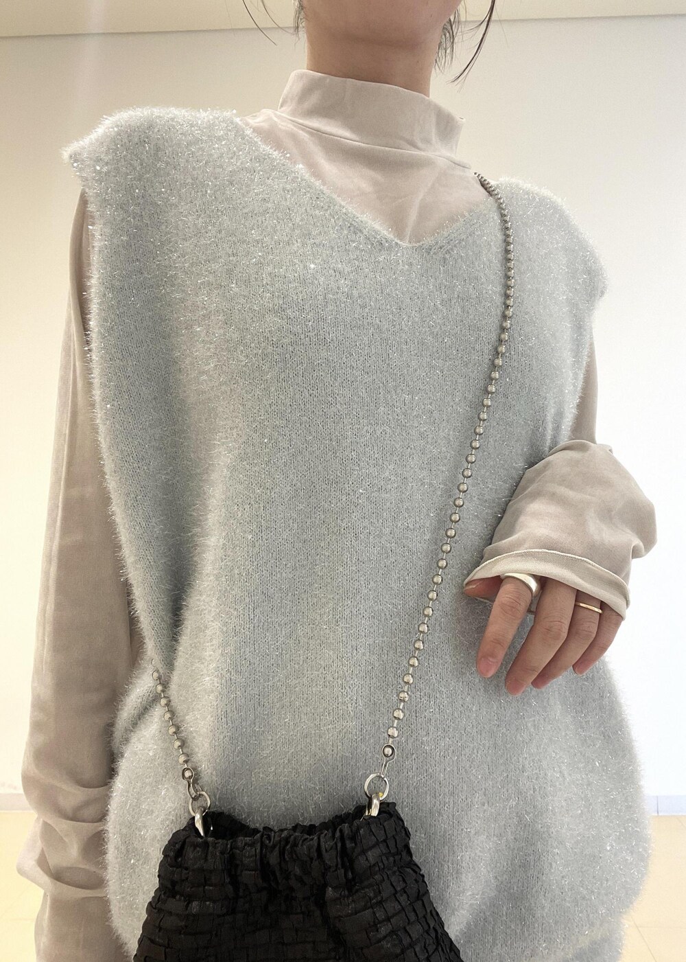 ブラック系のブーツ、ブラック系のスカート、ブラック系のショルダーバッグを着用したレディースの冬コーディネートの3枚目の写真