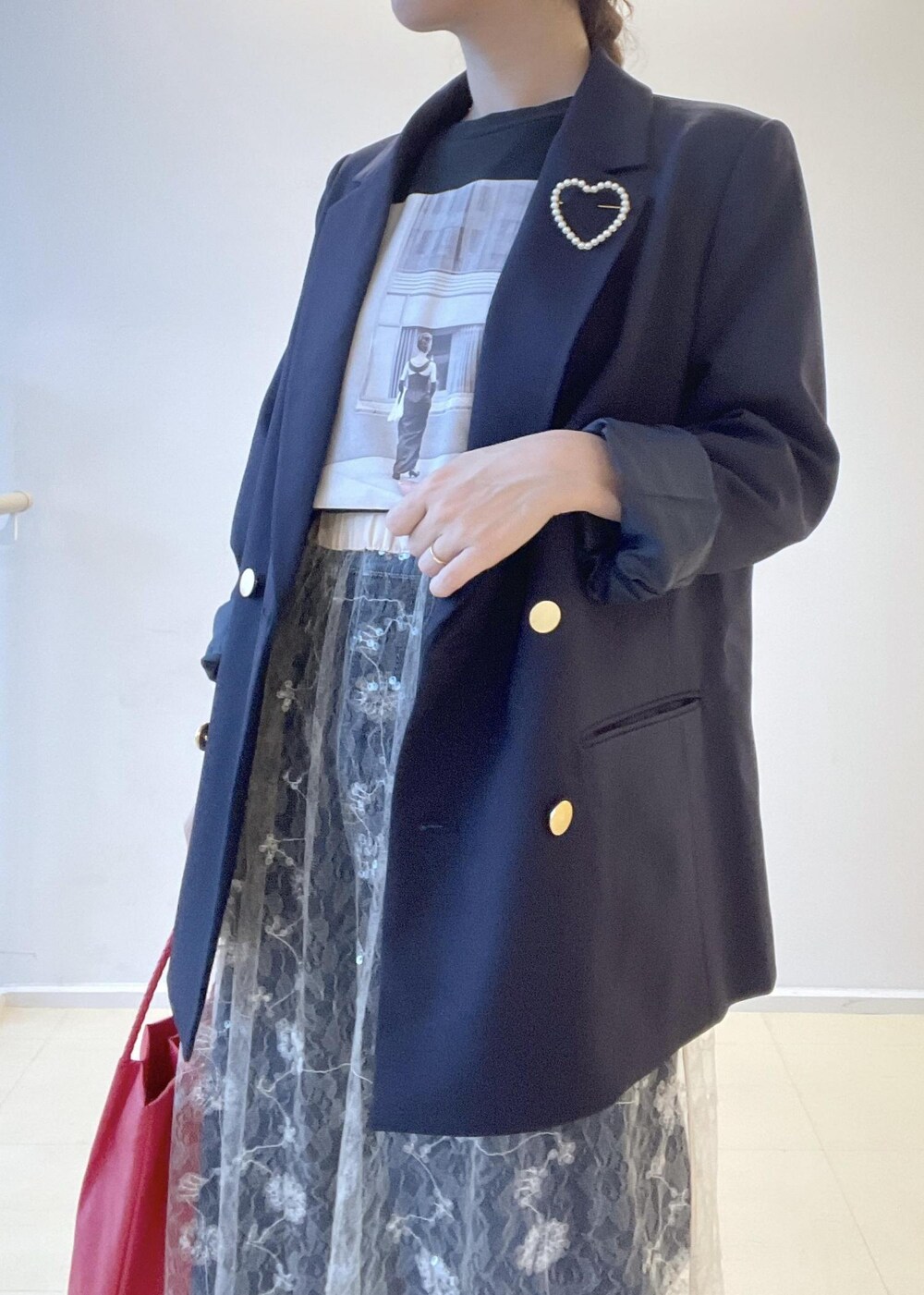 ホワイト系のスカート、ブラック系のTシャツ/カットソー、ブルー系のテーラードジャケットを着用したレディースの夏コーディネートの4枚目の写真