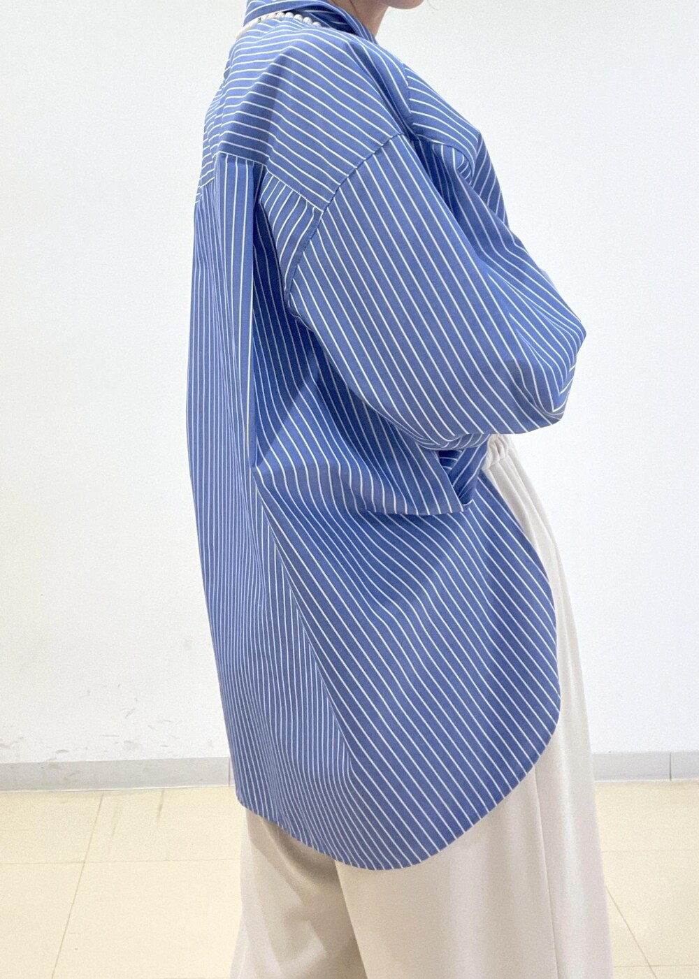 ブルー系のシャツ/ブラウス、ブラック系のボストンバッグ、ベージュ系のその他パンツを着用したレディースの春コーディネートの3枚目の写真