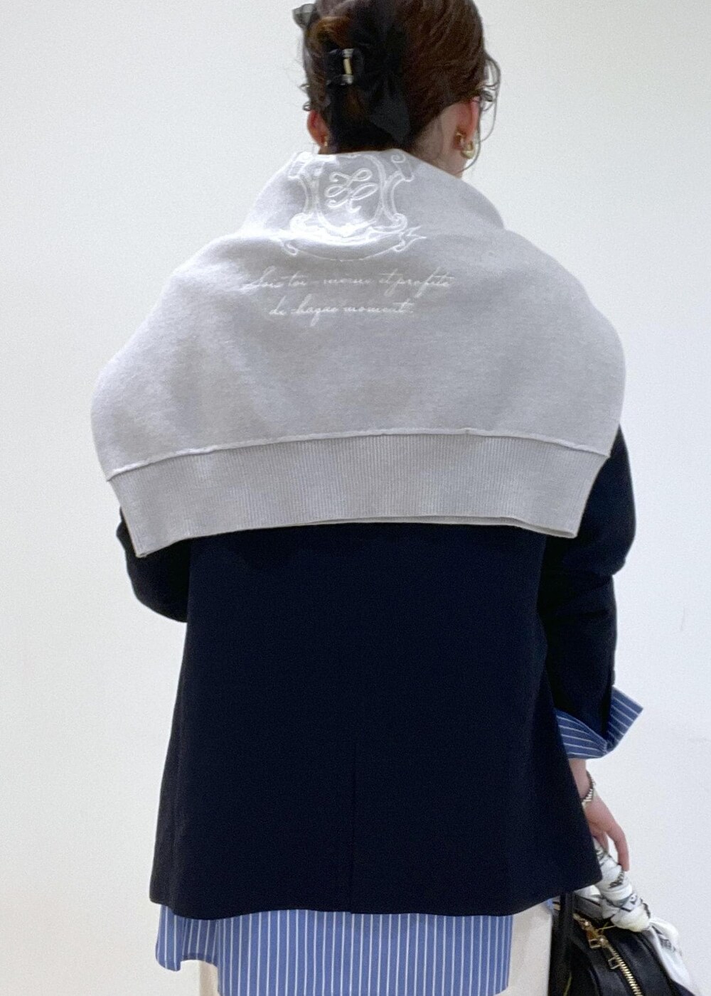 ブルー系のシャツ/ブラウス、グレー系のニット/セーター、ベージュ系のその他パンツを着用したレディースの春コーディネートの4枚目の写真