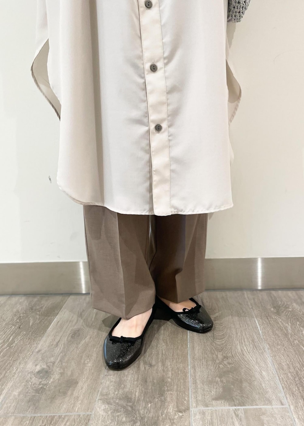 ブラック系のレインシューズ、シルバー系のショルダーバッグ、ベージュ系のシャツワンピースを着用したレディースの夏コーディネートの3枚目の写真