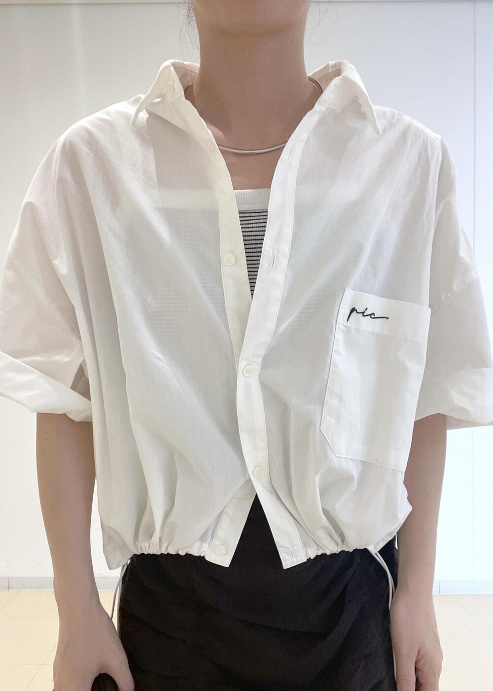 ホワイト系のタンクトップ、ホワイト系のシャツ/ブラウス、ブラック系のショルダーバッグを着用したレディースの夏コーディネートの4枚目の写真